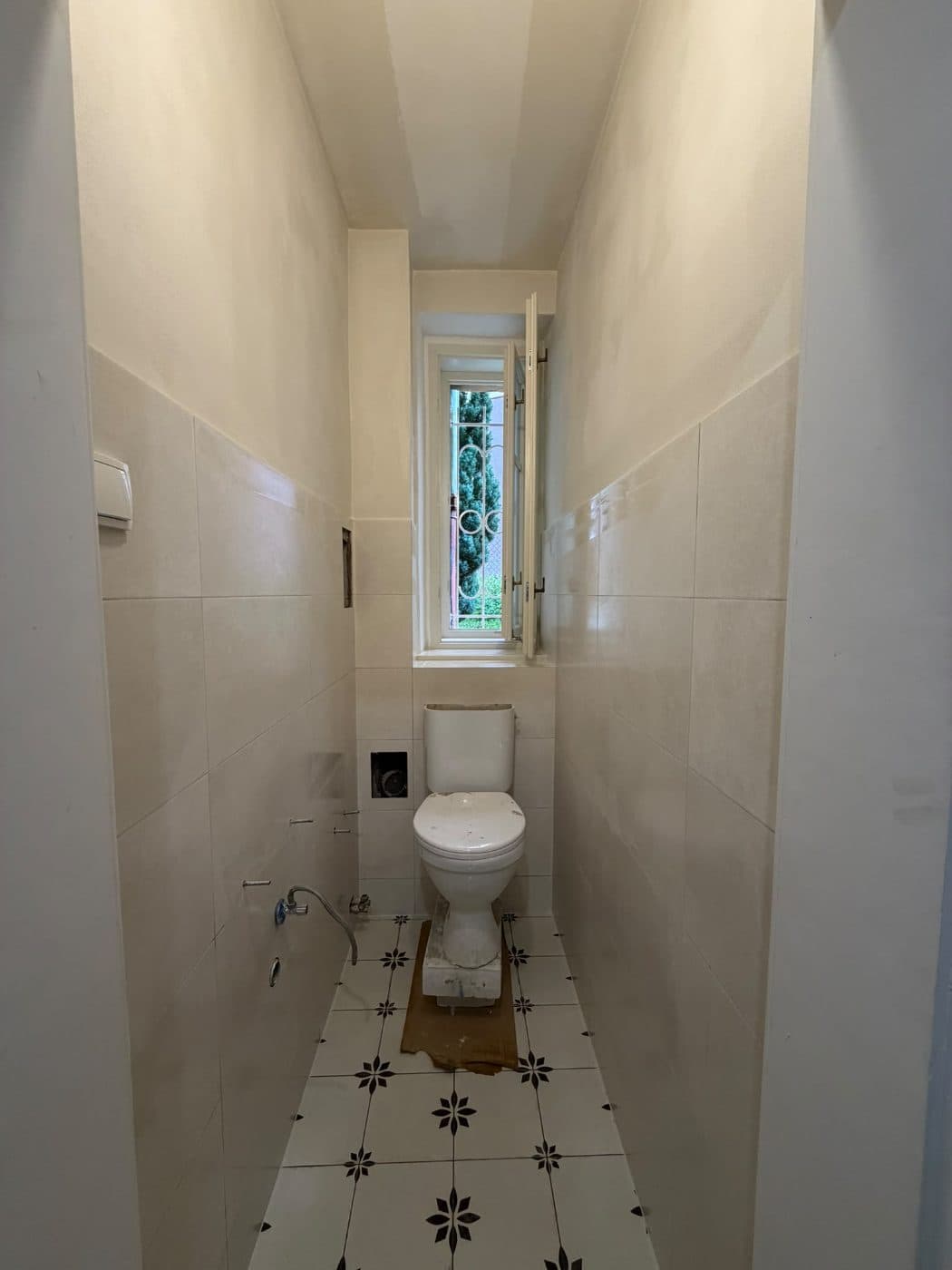 WC s novým velkoformátovým obkladem a ornamentální dlažbou před osazením umývátka